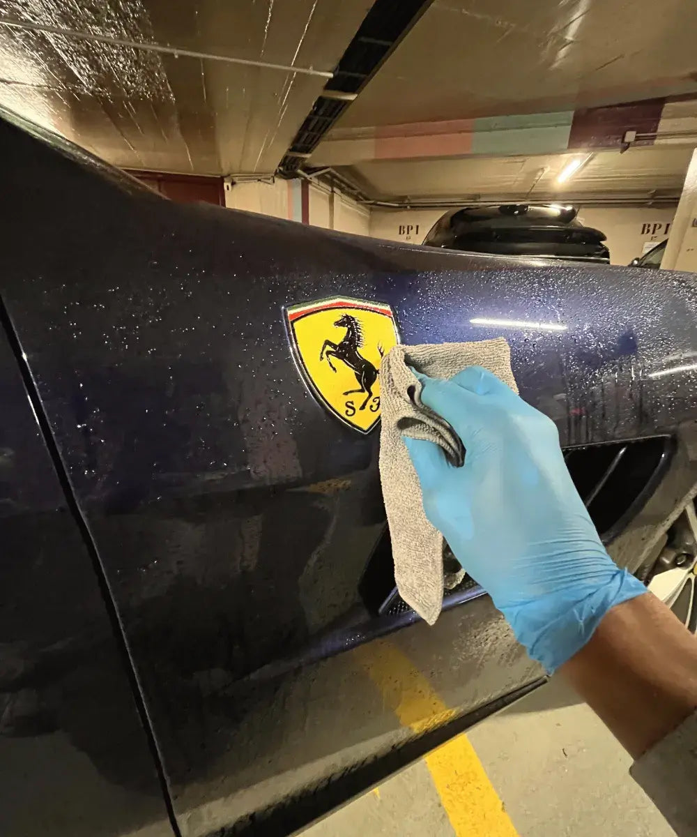 Nettoyage minutieux de la carrosserie d’une Ferrari avec microfibre à Argenteuil - Savoir et Détail