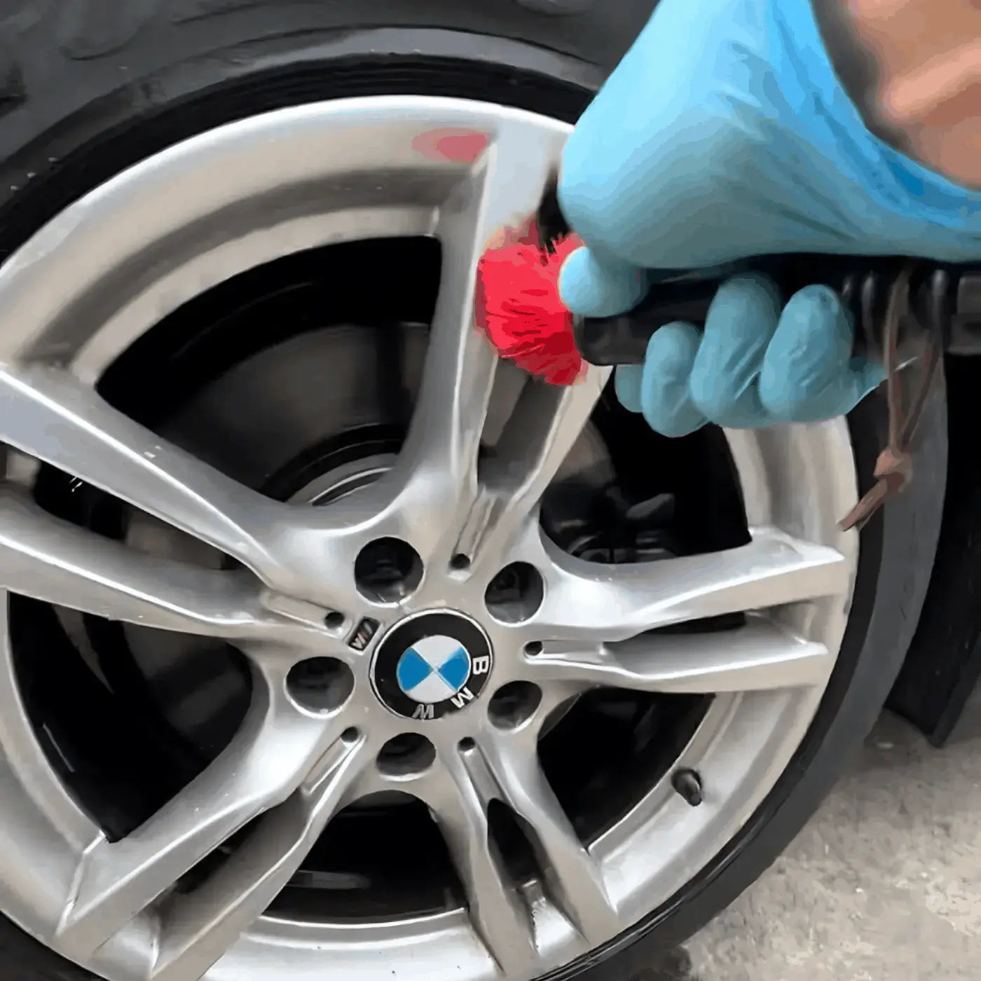 Gros plan sur le nettoyage minutieux d'une jante de voiture BMW avec une brosse de detailing par un professionnel à Sarcelles.